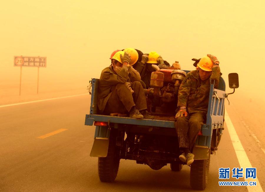 4月23日，一輛拉載公路施工人員的三輪車在沙塵暴中行駛在酒泉市瓜州縣城郊的公路上。
