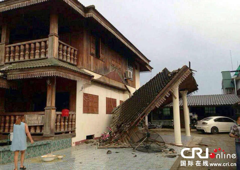 當(dāng)?shù)貢r(shí)間2014年5月5日，泰國(guó)清萊，一名婦女看著受損的房屋。 圖片來(lái)源：東方IC