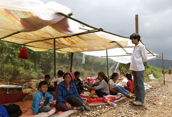 暴雨馬上來(lái)臨，村民們?cè)诤?jiǎn)易帳篷下躲雨。澎湃新聞 程藝輝 圖