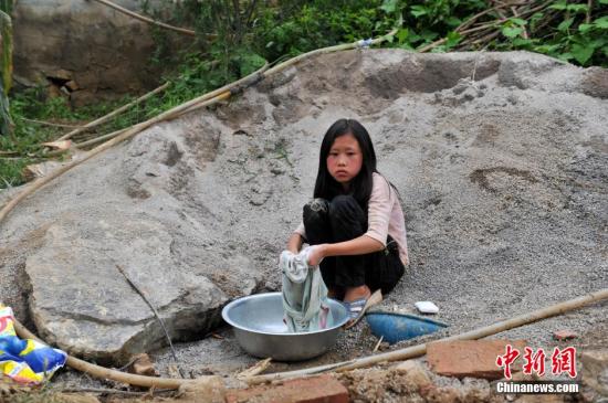 8月9日，云南巧家紅石巖村，10歲的劉鑫蕊在洗自己的衣服