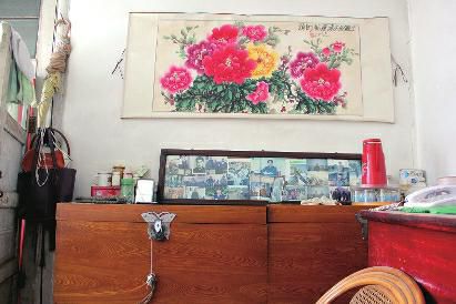 　陳會(huì)英將兒女的照片都裱起來，裝在一個(gè)大相框里，放在箱子上經(jīng)?？?，其中最多的就是劉金國的照片。