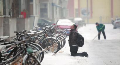 小伙子跪在樓前，一直抬頭看著樓上。 孫立國/攝