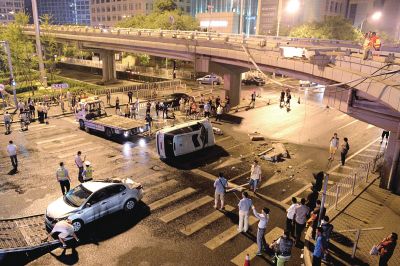 路虎沖下國貿(mào)橋砸中一輛起亞轎車，橋上厚達(dá)幾十厘米的水泥護(hù)欄被撞斷，碎石四處散落，數(shù)十群眾在現(xiàn)場圍觀。