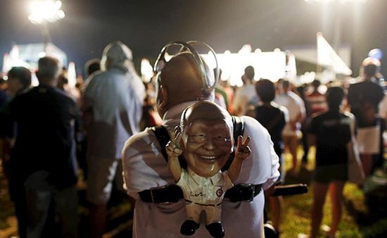 9月4日，新加坡，執(zhí)政黨的一場集會上，一名支持者背著一個李光耀的人偶。