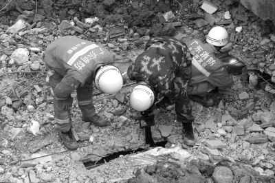 搜救人員正在用探視儀器觀看被掩埋層的情況。