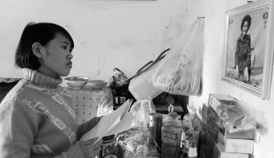 錢仁鳳站在母親遺像前。未能見母親最后一面是她的一大遺憾。