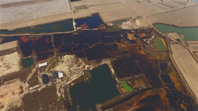 4月19日，廊坊市大城縣南趙扶鎮(zhèn)，津保路以北約八九百米處，一個巨大的污水坑中，水體呈現(xiàn)紅褐色。 新京報記者 尹亞飛 攝