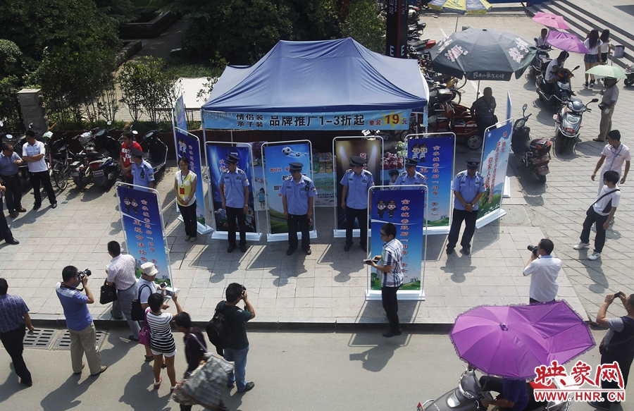 執(zhí)法人員用宣傳牌圍擋占道經(jīng)營攤位。