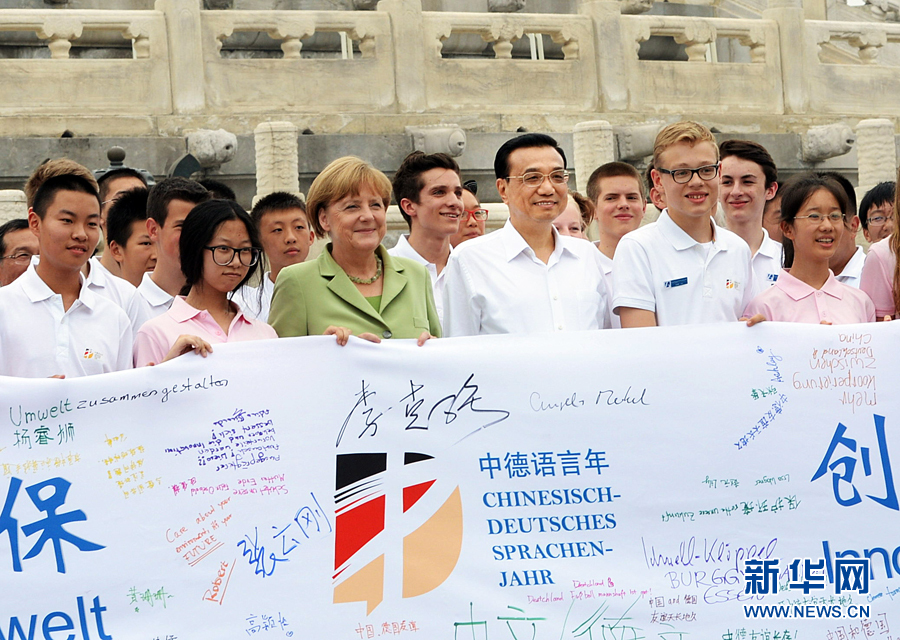 李克強同默克爾與青少年在天壇祈年殿前合影留念。