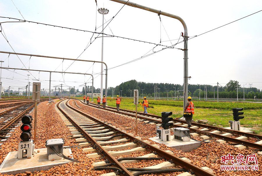 在太陽的直射下，檢修工人扛著沉重的設(shè)備向施工地點出發(fā)