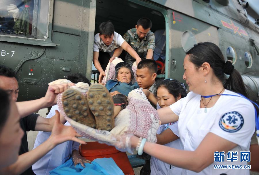 8月5日，醫(yī)護(hù)人員將一名通過直升機(jī)從震中轉(zhuǎn)運(yùn)出來的傷員運(yùn)下飛機(jī)。