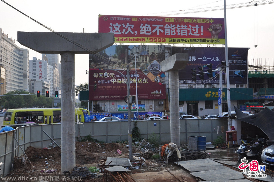 過(guò)街天橋一側(cè)的橋樁早已打好,可是對(duì)面的郵政銀行網(wǎng)點(diǎn)依舊在照常營(yíng)業(yè)。