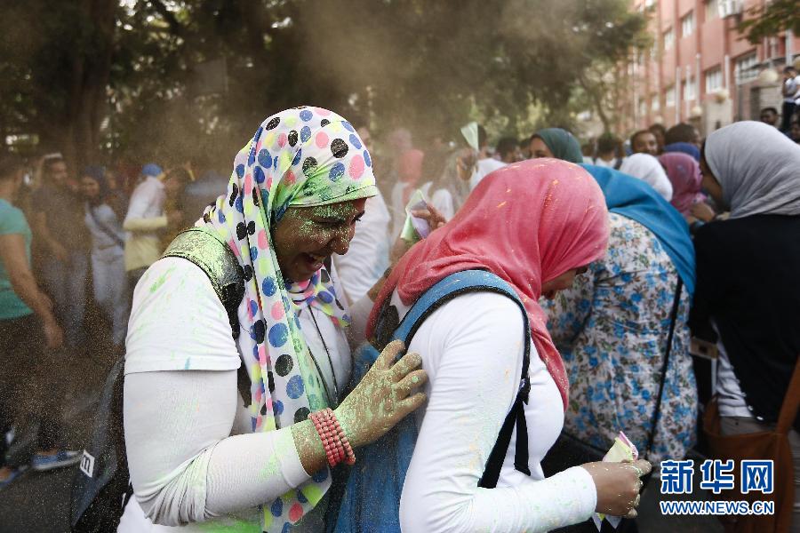 10月16日，在埃及首都開羅，兩名女青年在“彩色跑”活動(dòng)中躲避人們拋撒的彩色粉末。