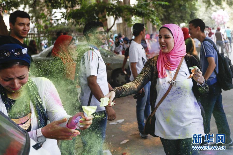 10月16日，在埃及首都開羅，一名女青年在“彩色跑”活動(dòng)中拋撒彩色粉末。