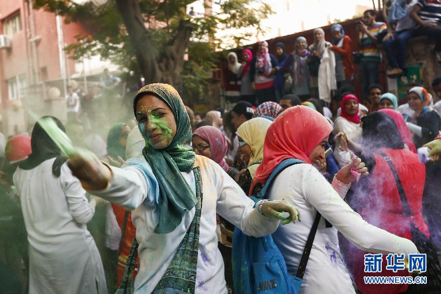 10月16日，在埃及首都開羅，一名女青年在“彩色跑”活動(dòng)中拋撒彩色粉末。