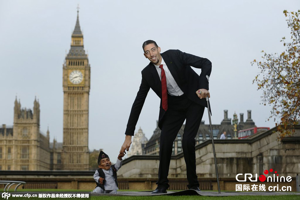 當地時間2014年11月13日，英國倫敦，世界上最矮的男子錢德拉·巴哈杜爾·唐吉與世界上最高的男子蘇