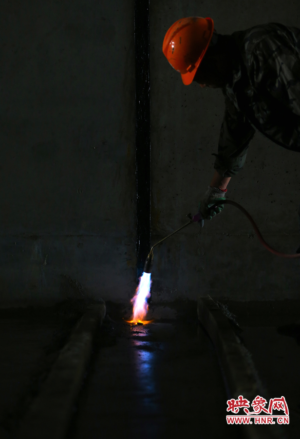 工人師傅用噴槍烘干地面，便于做防水處理