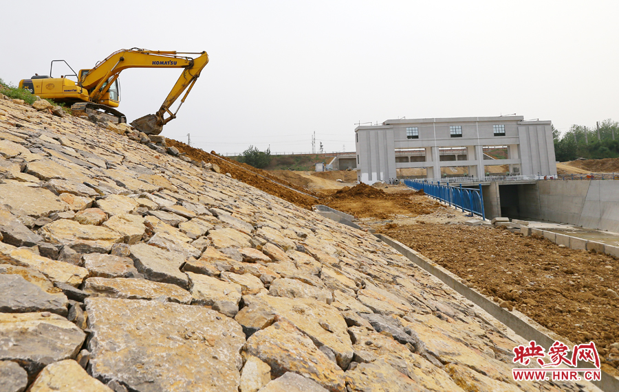 護(hù)堤上挖掘機進(jìn)行著最后的整理工作