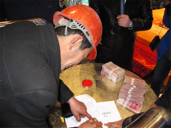 農(nóng)民工在現(xiàn)場領(lǐng)取工資。