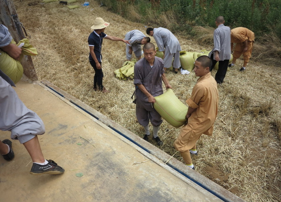 武僧將打包后的糧食集中至運(yùn)輸車(chē)輛上。