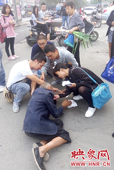 一些愛(ài)心市民在撥打了110和120后，上前給老人擦臉上的血跡。