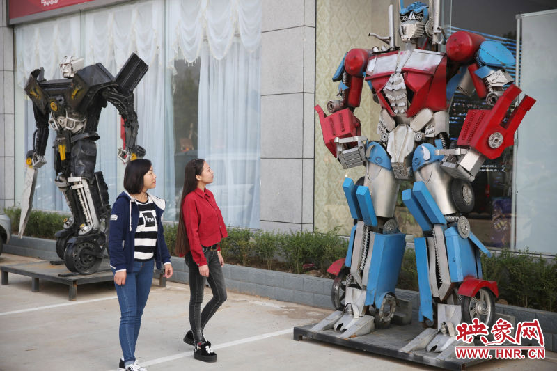 10月14日，市民在參觀河南省平頂山市寶豐縣一家企業(yè)門前的“變形金剛”。