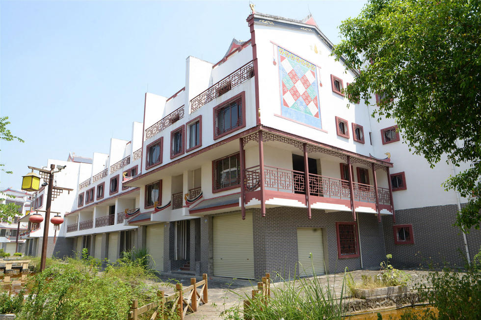 2016年7月26日，村民在廣西來賓市忻城縣隆達(dá)山水福城荒廢別墅間放牛。