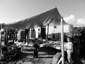 黎巴嫩一敘利亞難民營(yíng)，難民支起攤鋪賣衣服掙錢。