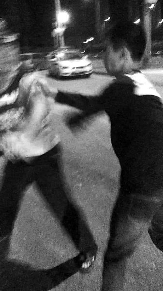 一名男子扯著民警的反光背心一路追打。