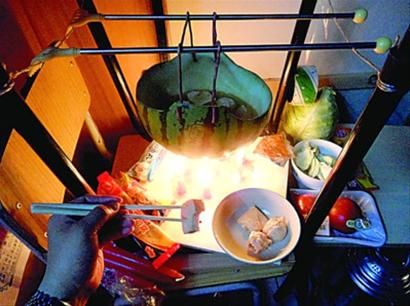 兩張椅子被面對面疊在一起，穿了兩根線的西瓜皮就懸空在椅腳中間，下面有蠟燭加熱，這就是西瓜火鍋。