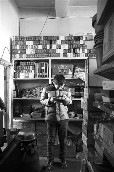 1月21日，周瑋在自家的超市里玩計算器。