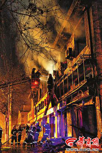 昨日22時10分，西安市豐慶路南小巷南口，消防官兵架梯子登上二樓施救 本組圖片由本報記者 閆文青 攝