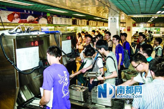 昨日，華南理工大學(xué)一食堂內(nèi)，學(xué)生們正在使用新安裝的自動打飯機(jī)打飯。中新社發(fā)