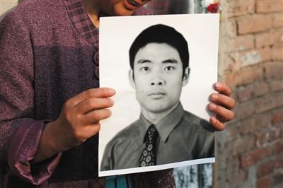 5月19日，朝陽(yáng)北路，母親捧著張東文的遺像。新京報(bào)記者 侯少卿 攝