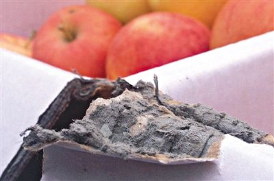 8月29日，新發(fā)地市場(chǎng)，一箱用“加重紙箱”包裝的蘋果正待售，紙箱夾層內(nèi)灰黑色的增重填充物清晰可見