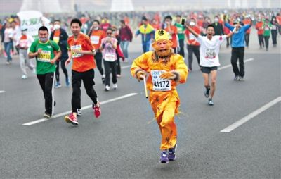 長(zhǎng)安街，一名打扮成孫悟空的參賽者在北馬隊(duì)伍里飛奔。 本版攝影/新京報(bào)記者 吳江 李飛 王嘉寧 吳江