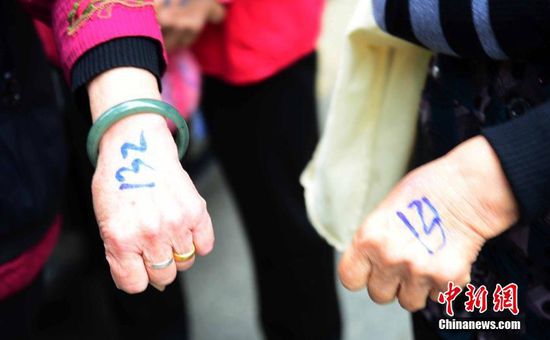 圖為10月28日，在江西九江市一家羊絨皮草服裝服飾博覽會(huì)現(xiàn)場，老人們正在頂著寒風(fēng)排隊(duì)等待領(lǐng)取10元代金劵。