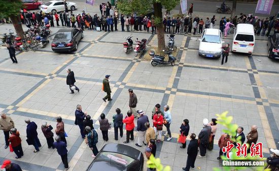 圖為10月28日，在江西九江市一家羊絨皮草服裝服飾博覽會(huì)現(xiàn)場，老人們正在頂著寒風(fēng)排隊(duì)等待領(lǐng)取10元代金劵。