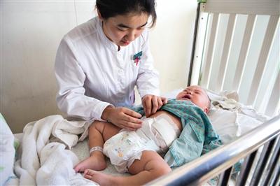 昨日，北京兒童醫(yī)院，護(hù)士為即將出院的被扎鋼針女嬰檢查傷口恢復(fù)情況。記者 高瑋 攝