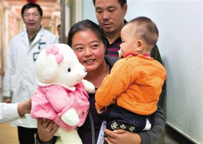 昨日上午，被扎針女嬰的母親抱著孩子和醫(yī)護(hù)人員送的玩偶準(zhǔn)備出院，院方稱孩子術(shù)后恢復(fù)良好。記者 高瑋 攝