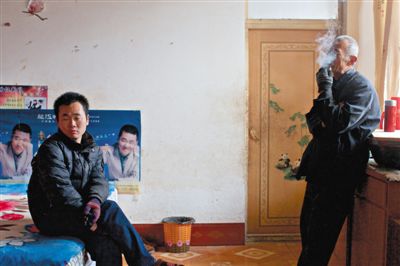 父親抽煙，兒子不語。逃跑的越南新娘，給袁迎賓父子帶來的是失落。新京報記者 周崗峰 攝