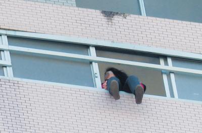 28樓的窗臺上坐著一名女子，其兩條腿耷拉在室外，不停地擺動。