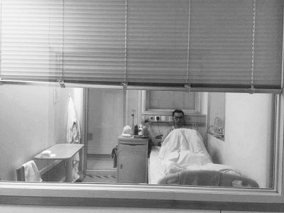 楊杰在醫(yī)院隔離病房中，沖記者揮了揮手。