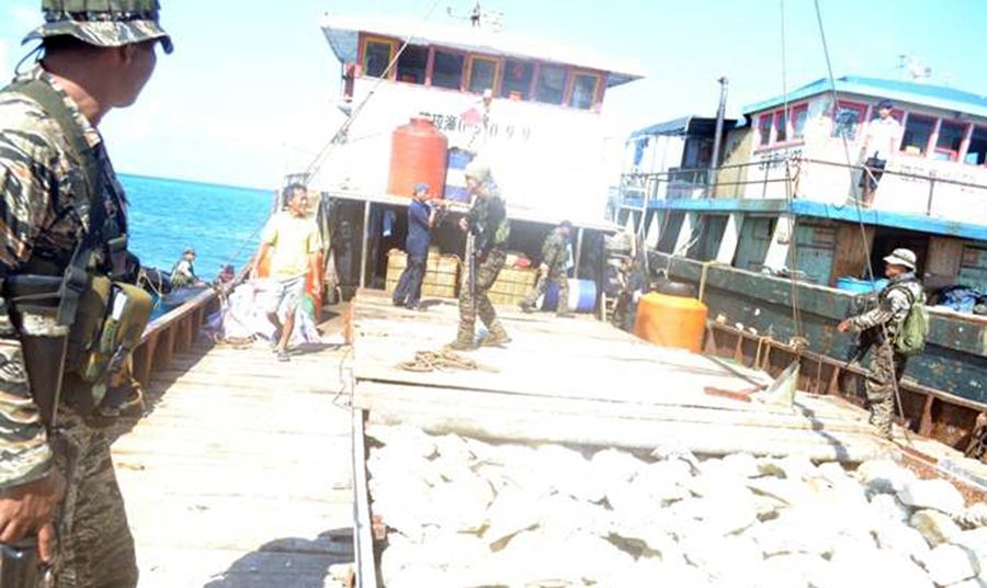圖為菲律賓海軍持槍檢查中國漁民的照片。