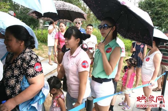 佩戴信息廣播臂貼的聽眾們在排隊(duì)等候坐帆船。