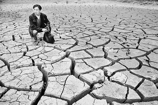 蹲在干涸的田地里，焦裕祿為饑餓的百姓揪心不已 《焦裕祿》劇照