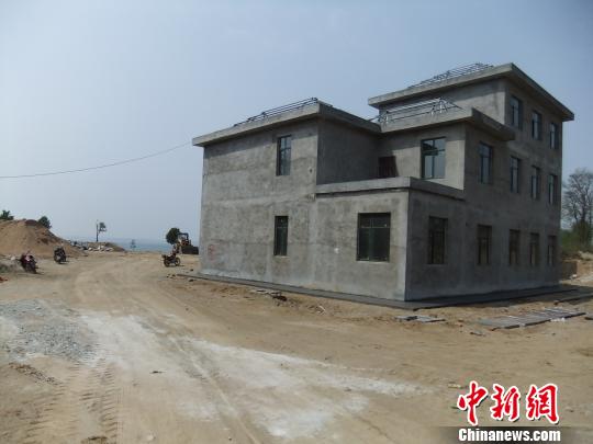 鴨河水庫庫區(qū)邊的新建別墅，一面墻上寫著“拆”，另一邊在加緊施工。吳揚(yáng)　攝