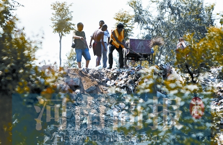 有人正在傾倒建筑垃圾，不遠(yuǎn)處就是村民的水井